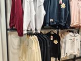 beaucoup de chemises suspendues à un portant dans un magasin