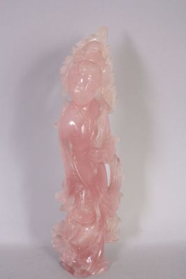 une statue rose posée sur une surface blanche