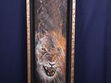 a painting of a lion in a wood frame on a blue background