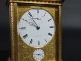 a gold clock with roman numerals on the face