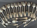 a lot of silver spoons and forks arranged in a circle