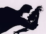 silhouette of a man and a woman holding a dog in their arms