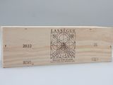 La boîte en bois contient une bouteille de vin et une autre boîte en bois sur laquelle est apposée une étiquette.