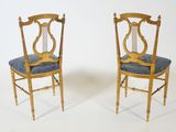pair of antique chairs with blue upholstered cushions on them