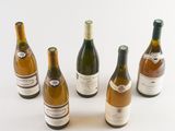 six bottles of wine are arranged in a circle on a white surface