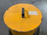 a yellow drum with a sticker on it in a warehouse