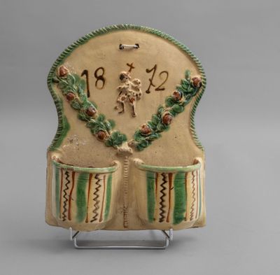 a ceramic clock with a design on it on a stand