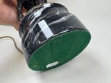 a person holding a black and green cup on a table