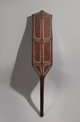 an old wooden paddle with a decorative design on it