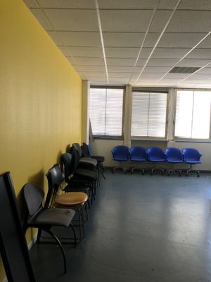 une pièce avec beaucoup de chaises et un mur jaune