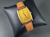 a close up of a watch on a pillow on a pillow