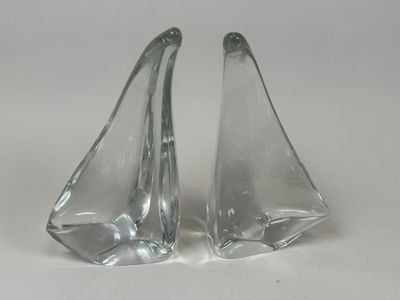 paire de salières et poivrières en forme de voiliers en verre transparent sur fond blanc