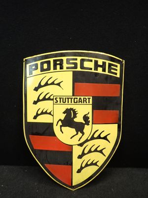 un gros plan sur l'emblème Porsche sur fond noir