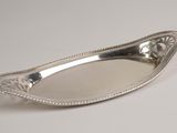 an antique silver plate with a decorative design on the edge