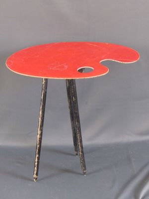 une table rouge sur laquelle se trouve une palette de peinture rouge