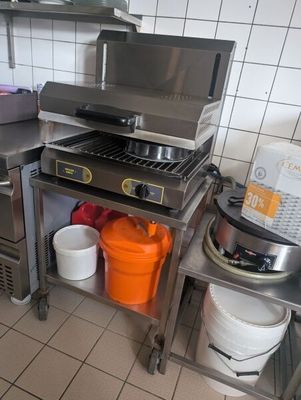 a kitchen with a stove, sink, and pots on the counter
