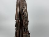 an antique bronze statue of a woman holding a dog