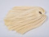 a close up of a piece of blonde hair on a white surface