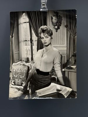 photographie en noir et blanc d'une femme assise à un bureau avec un livre