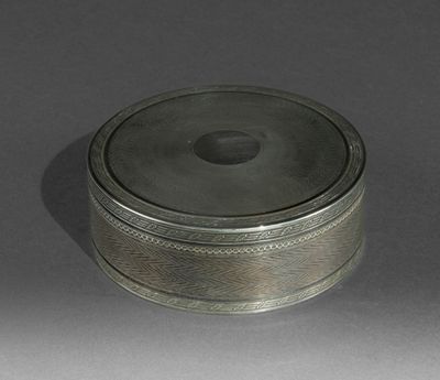 une boîte ancienne en argent avec un couvercle, posée sur une table