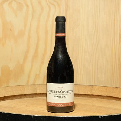 a bottle of wine sitting on top of a barrel