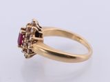 a close up of a gold ring with a ruby stone