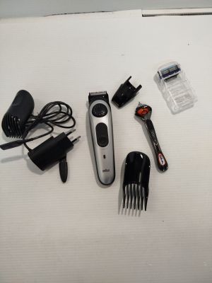 une tondeuse à cheveux, un peigne et d'autres accessoires pour les cheveux disposés sur une table