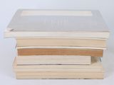 three books stacked on top of each other on a white surface