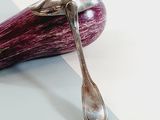 an eggplant with a spoon sitting on top of it