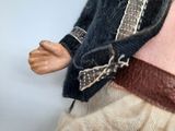 a doll that is wearing a skirt and a jacket
