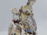 une figurine représentant une femme et un enfant jouant avec un chien