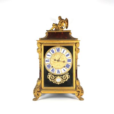 une horloge dorée ornée de chiffres romains bleus
