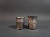 two silver cups sitting next to each other on a table