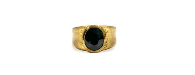 a close up of a gold ring with a black stone