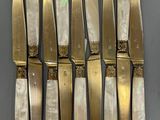 six knives are lined up in a row on a table