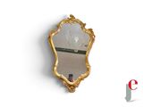 a gold mirror on the wall with a reflection of a person taking a selfie