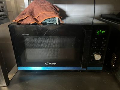 a microwave with a cloth on top of it in a kitchen