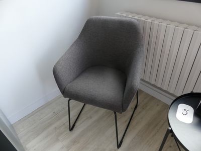 une chaise posée dans un coin, près d'un radiateur