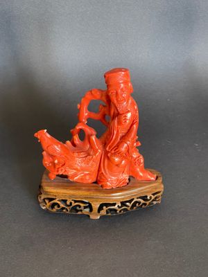 une figurine orange représentant un homme et une femme assis sur un rocher