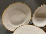 three white and gold china plates with gold rims on them