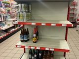 une étagère sur laquelle sont posées plusieurs bouteilles de vin, dans un magasin