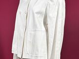 a white jacket on a mannequin stand against a red background