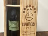 the bottle of wine is in the wooden box on the table