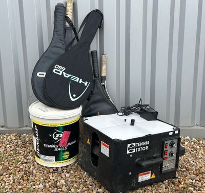 une guitare, un étui à guitare et un seau de peinture posé par terre