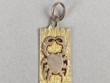 un pendentif en forme de crabe argenté et doré sur fond blanc
