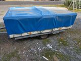 a blue tarp covering a trailer on the side of the road