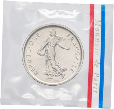 un gros plan d'une pièce de monnaie dans un sachet en plastique orné d'une bande rouge, blanche et bleue