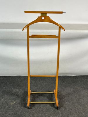 une photo d'un porte-manteau en bois sur lequel est accroché un cintre