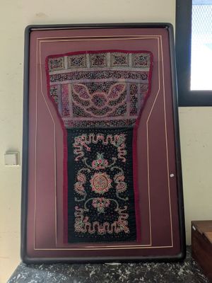 an old picture of a carpet hanging on a wall next to a window
