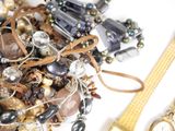 a pile of assorted jewelry on a white surface